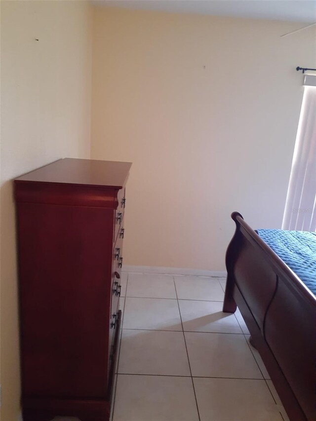 bedroom with baseboards and light tile patterned floors