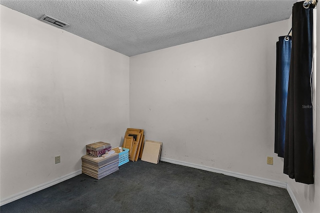 interior space with dark carpet and a textured ceiling