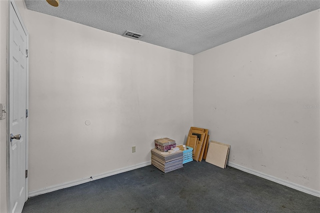 carpeted empty room with a textured ceiling