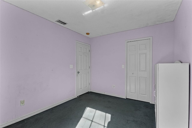 carpeted spare room with a textured ceiling