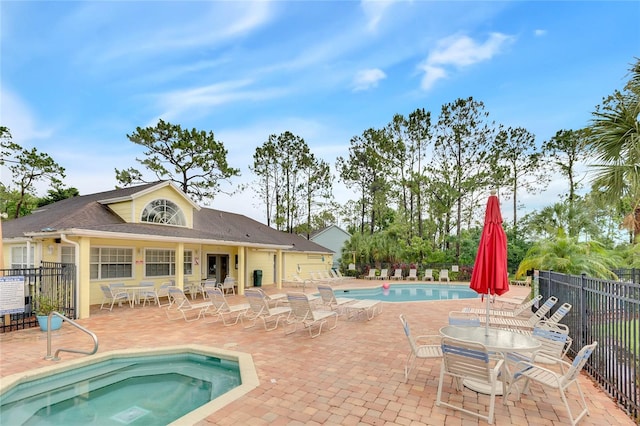 view of swimming pool with a patio and a hot tub