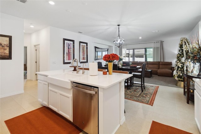 kitchen featuring white cabinetry, sink, stainless steel dishwasher, pendant lighting, and a kitchen island with sink