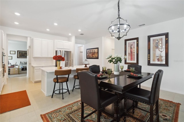 dining space with sink, light tile patterned floors, and a notable chandelier