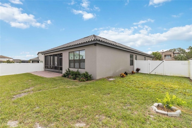 back of house with a sunroom and a yard