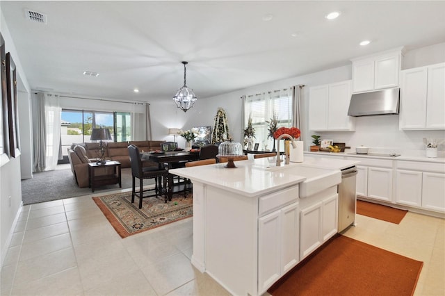 kitchen featuring pendant lighting, dishwasher, a kitchen island with sink, sink, and white cabinetry