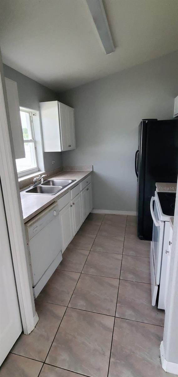 kitchen featuring white cabinets, light tile patterned floors, white appliances, and sink