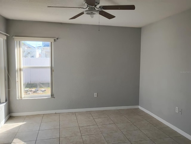 tiled spare room featuring plenty of natural light and ceiling fan