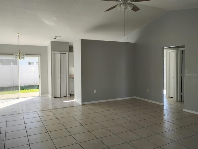 unfurnished living room featuring light tile patterned floors, ceiling fan with notable chandelier, and high vaulted ceiling