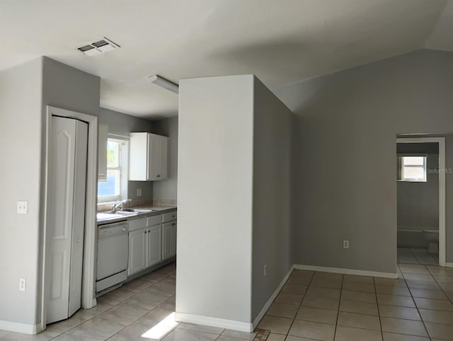 kitchen with dishwasher, white cabinets, a healthy amount of sunlight, and light tile patterned flooring