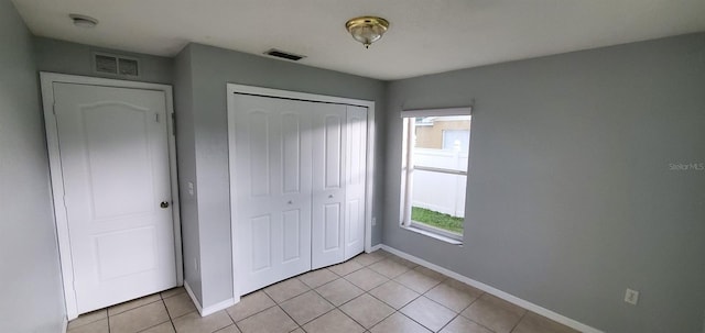 unfurnished bedroom with light tile patterned floors and a closet