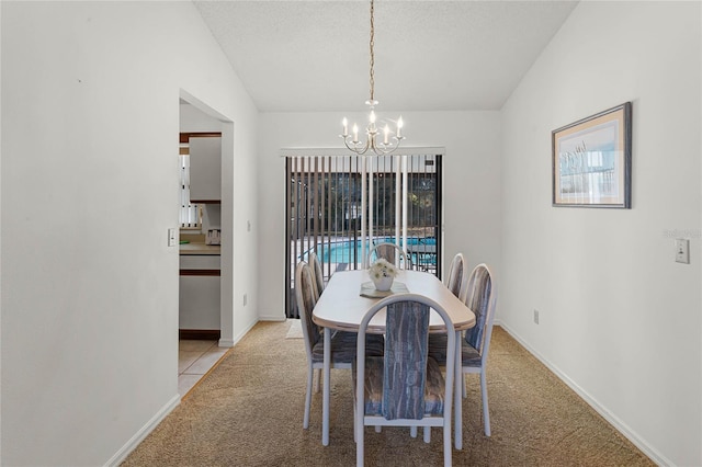 dining area with a notable chandelier, a healthy amount of sunlight, light colored carpet, and vaulted ceiling