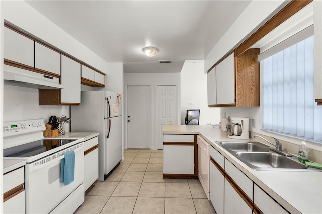 kitchen featuring white appliances, sink, light tile patterned floors, white cabinetry, and kitchen peninsula