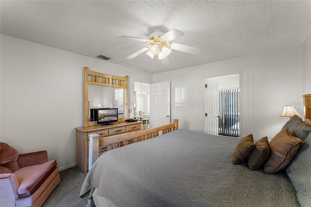 bedroom with ceiling fan, carpet floors, and a textured ceiling