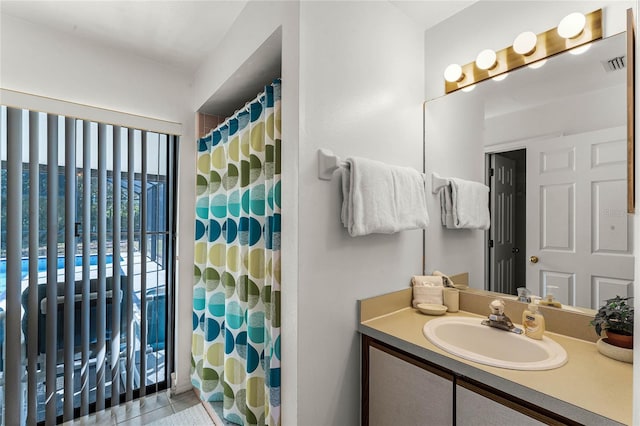 bathroom featuring tile patterned flooring, vanity, and walk in shower