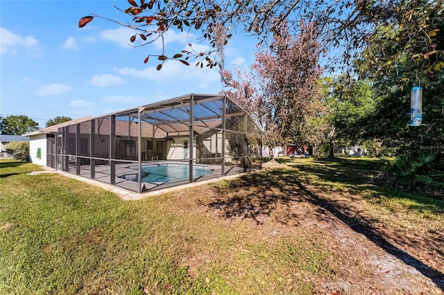 view of pool featuring a lawn and glass enclosure