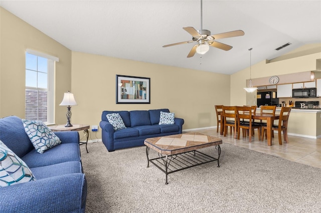 living room with tile patterned floors, ceiling fan, and vaulted ceiling