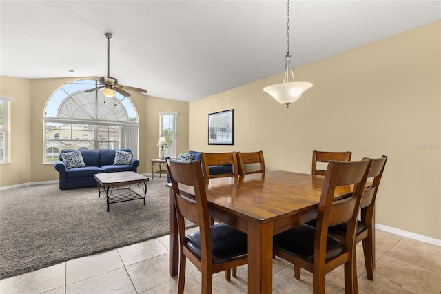 tiled dining area with ceiling fan and lofted ceiling