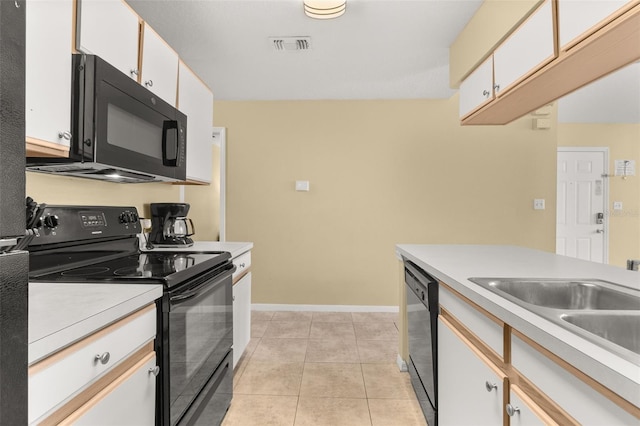 kitchen with white cabinetry, sink, light tile patterned flooring, and black appliances