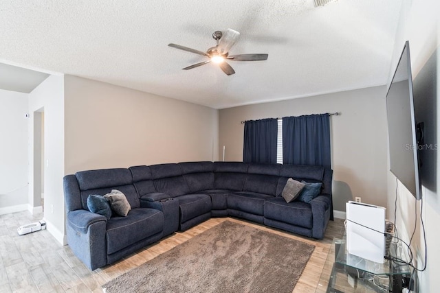 living room with hardwood / wood-style floors, ceiling fan, and a textured ceiling