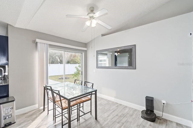 dining area featuring a textured ceiling, vaulted ceiling, light hardwood / wood-style flooring, and ceiling fan