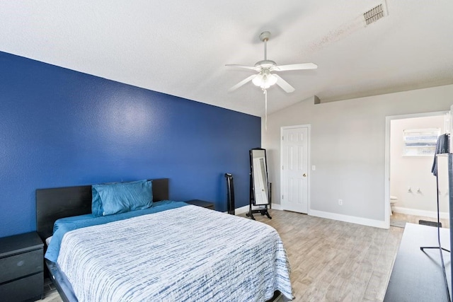 bedroom featuring connected bathroom, ceiling fan, lofted ceiling, and light wood-type flooring