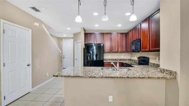1336 Chelsea Dr, Davenport, FL 33897 - kitchen with black appliances, a peninsula, light stone counters, light tile patterned floors, and decorative light fixtures