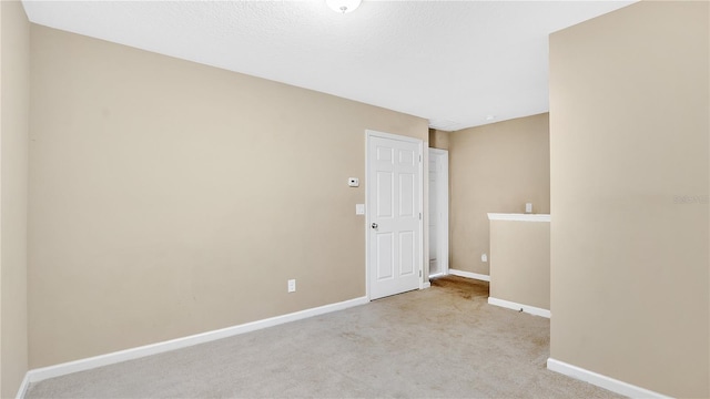 carpeted empty room with a textured ceiling