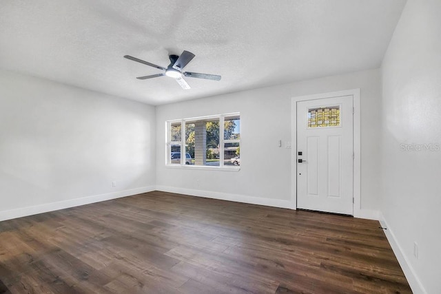 foyer entrance with a textured ceiling, dark hardwood / wood-style flooring, and ceiling fan