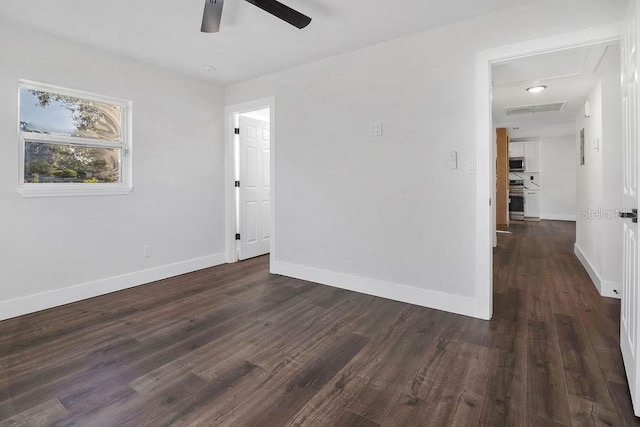 empty room featuring ceiling fan and dark wood-type flooring