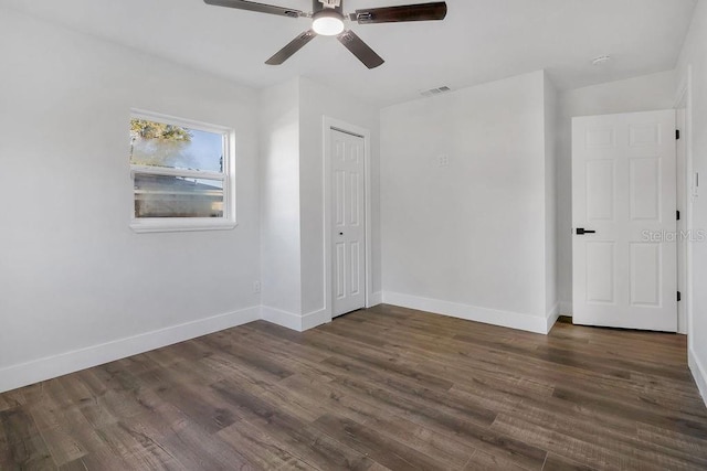 spare room featuring ceiling fan and dark wood-type flooring