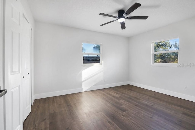 empty room with ceiling fan and dark wood-type flooring