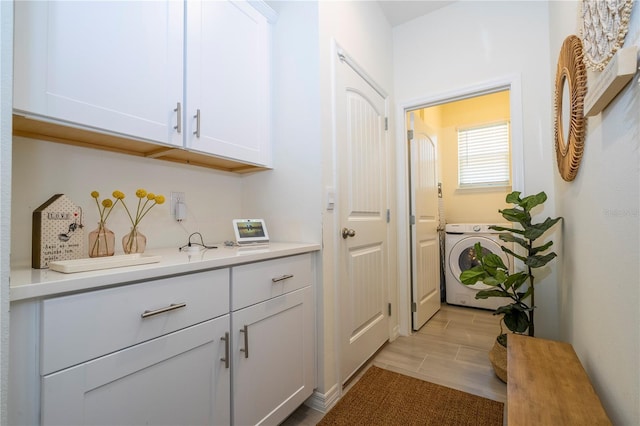 bar with white cabinets, light wood-type flooring, and washer / clothes dryer