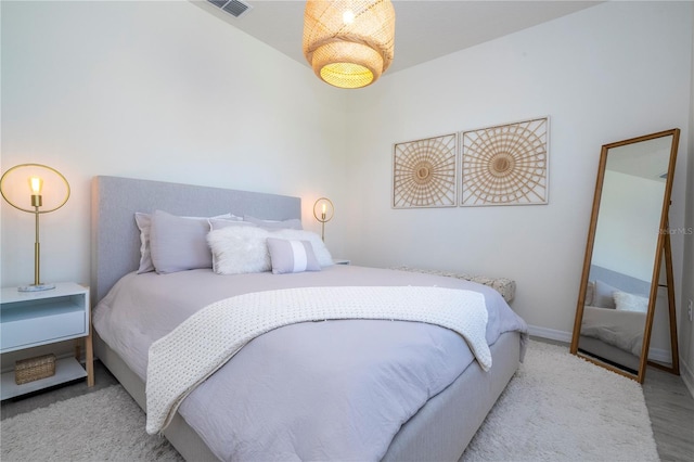 bedroom featuring lofted ceiling and light wood-type flooring