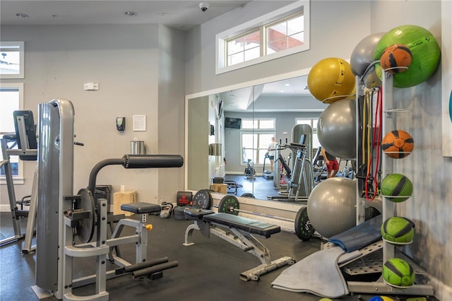 gym with a high ceiling and a healthy amount of sunlight