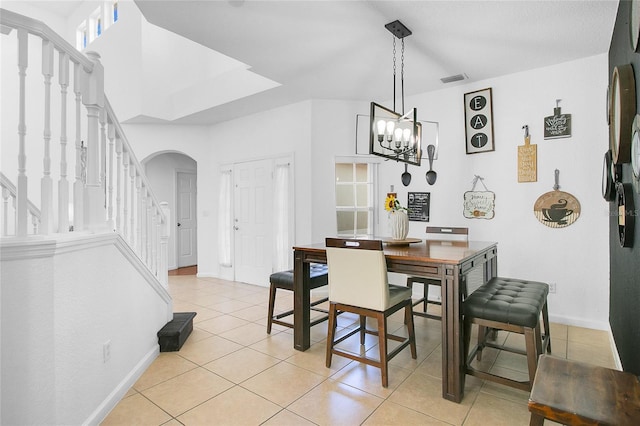 dining room featuring light tile patterned flooring and an inviting chandelier