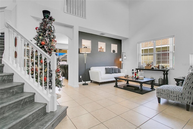 tiled living room with a towering ceiling