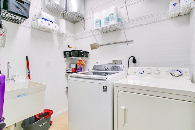 clothes washing area featuring separate washer and dryer and sink