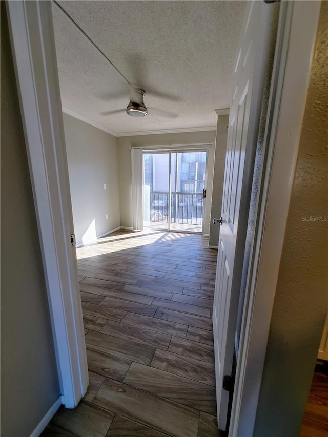 corridor with hardwood / wood-style floors, a textured ceiling, and ornamental molding