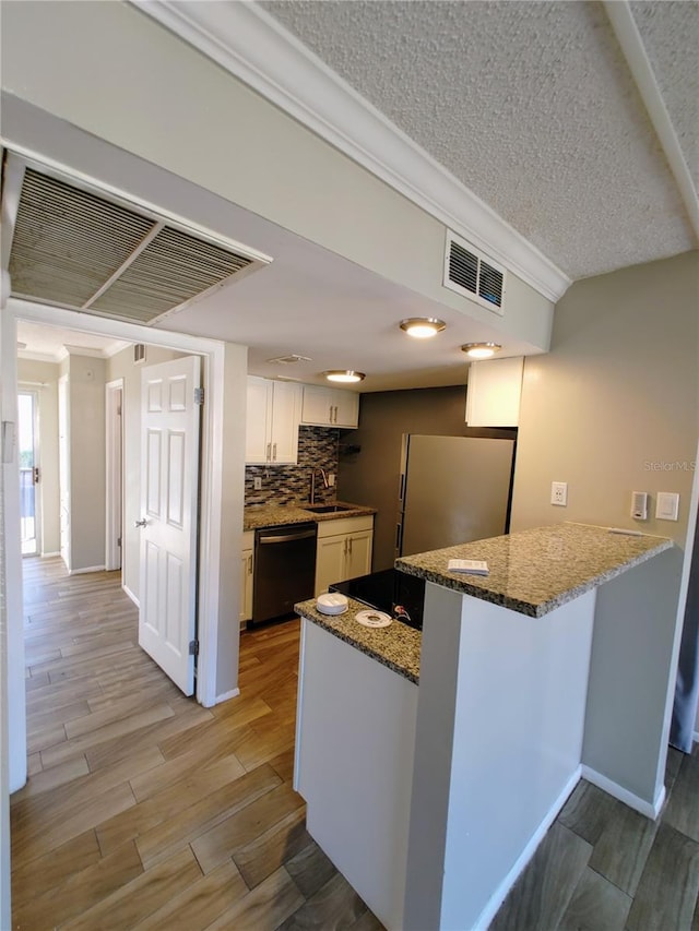 kitchen featuring white cabinetry, dishwasher, kitchen peninsula, light hardwood / wood-style floors, and a textured ceiling