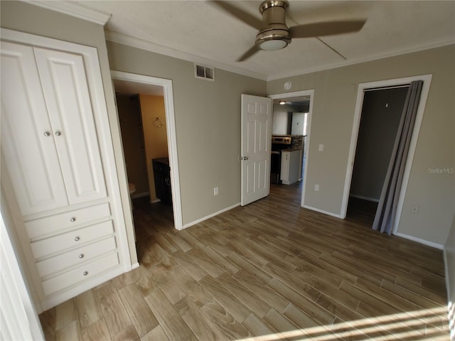 unfurnished bedroom featuring hardwood / wood-style floors, ceiling fan, ornamental molding, and ensuite bathroom