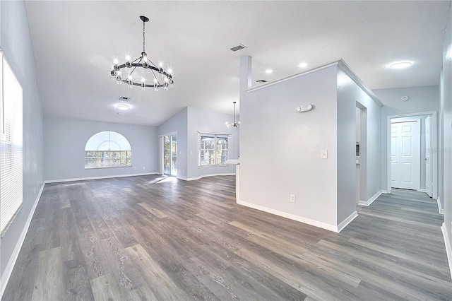 spare room with vaulted ceiling, dark hardwood / wood-style flooring, a textured ceiling, and an inviting chandelier