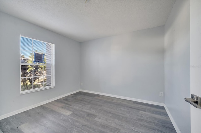 empty room featuring dark wood-type flooring and a textured ceiling