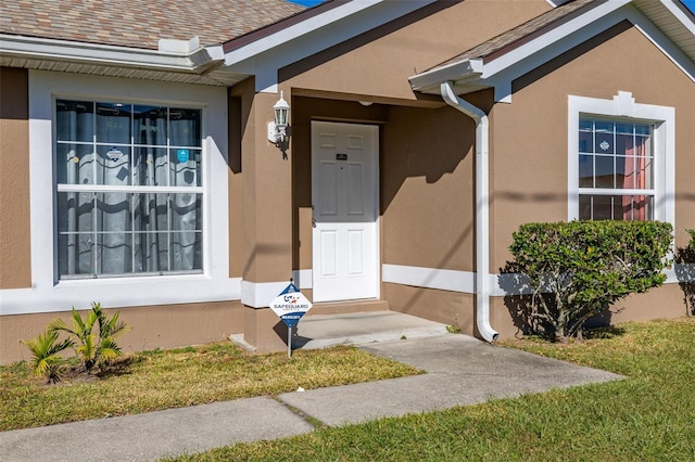 property entrance featuring a lawn