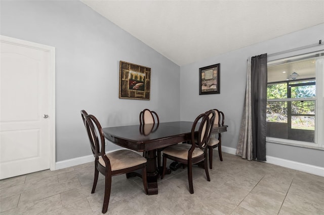 tiled dining room with lofted ceiling