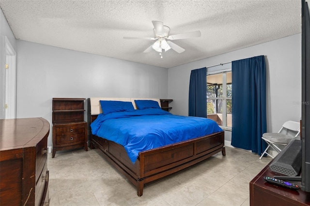 bedroom with ceiling fan, light tile patterned flooring, and a textured ceiling