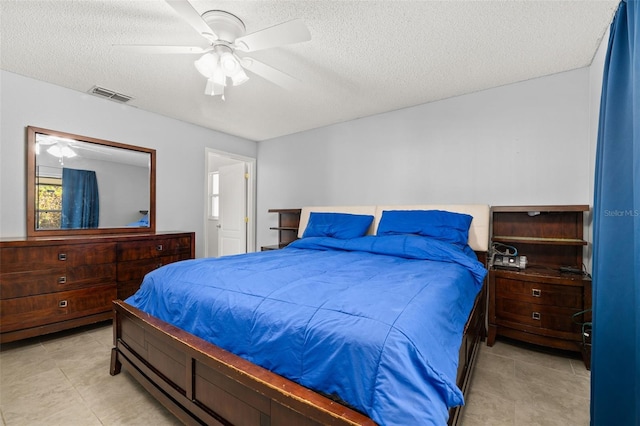 bedroom with a textured ceiling and ceiling fan