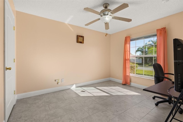 tiled home office with ceiling fan and a textured ceiling