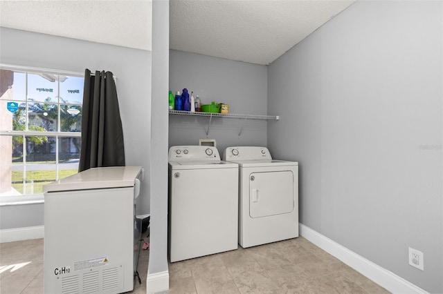 laundry area featuring washing machine and clothes dryer and a textured ceiling