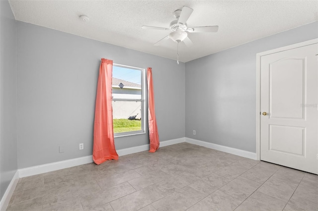 tiled spare room featuring ceiling fan and a textured ceiling