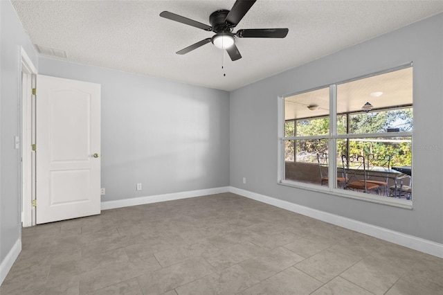 empty room featuring a textured ceiling, ceiling fan, and light tile patterned flooring